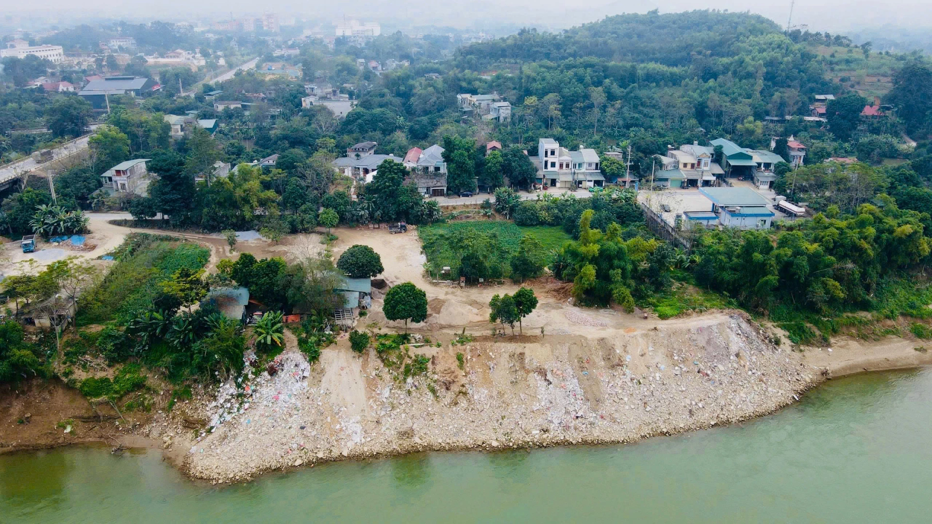 Thiên tai ngày càng khắc nghiệt, nhưng điều đáng nói là nhân tai đang góp phần làm trầm trọng thêm những hệ lụy ấy. Hành lang thoát lũ bị lấn chiếm bởi nhà ở, công trình xây dựng dọc bờ sông khiến dòng nước khi lũ về không còn không gian phân tán, buộc phải dồn lực tấn công vào những khu vực yếu thế nhất. Không ít khu vực xảy ra tình trạng san đào, đổ đất, lấn chiếm sông Lô khiến thay đổi dòng chảy, gia tăng sạt lở và suy giảm hệ sinh thái sông. Thậm chí có nhiều vụ việc xảy ra từ lâu nhưng chưa được khắc phục triệt để.