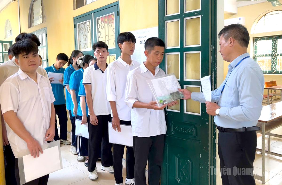Cán bộ coi thi tại điểm thi trường THPT Ỷ La kiểm tra, đối chiếu thông tin thí sinh trước khi vào phòng thi Ảnh: Thuý Nga