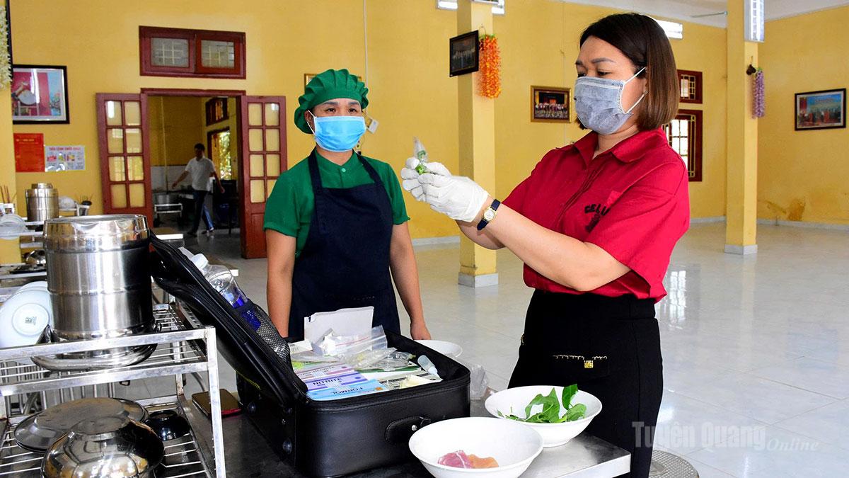 Cán bộ Phòng an toàn thực phẩm, Sở Y tế lấy mẫu test nhanh thực phẩm tại điểm thi trường Phổ thông dân tộc nội trú THPT Tuyên Quang.