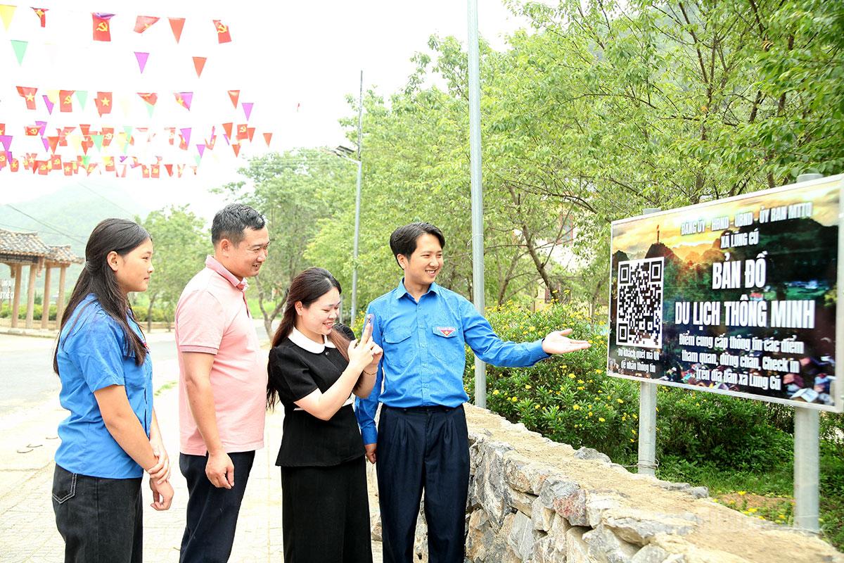 Đoàn viên thanh niên xã Lũng Cú hướng dẫn du khách quét mã QR để truy cập bản đồ 
du lịch thông minh.