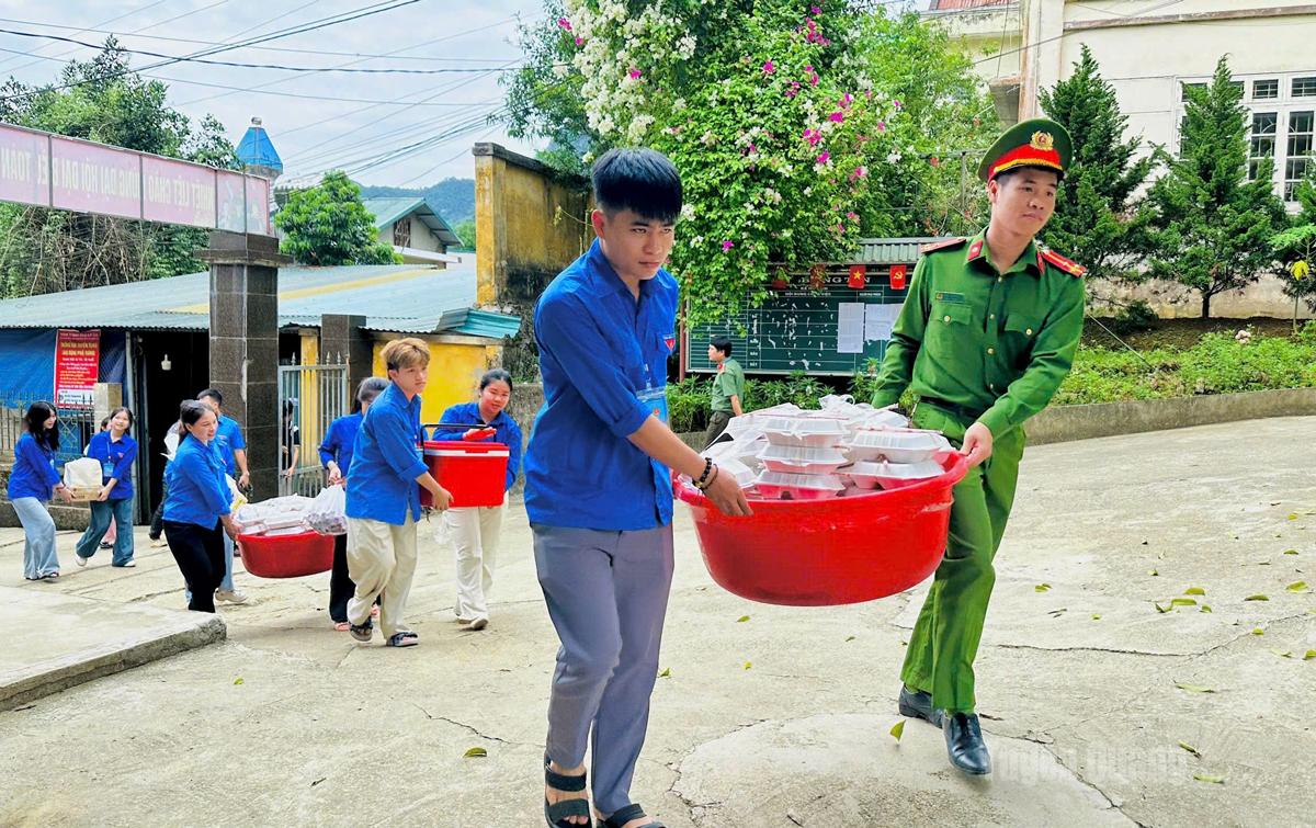 Lực lượng Tiếp sức mùa thi tiếp nhận đồ ăn trưa cho các thí sinh sau khi hoàn thành bài thi tại điểm trường THCS và THPT Thượng Lâm. Ảnh: Như Quỳnh