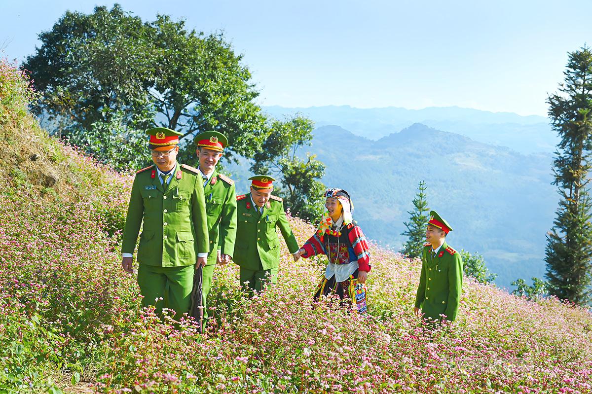Sự gần gũi, đồng hành của sắc phục xanh cùng đồng bào dân tộc Lô Lô trong trang phục truyền thống trên những triền hoa tam giác mạch rực rỡ.