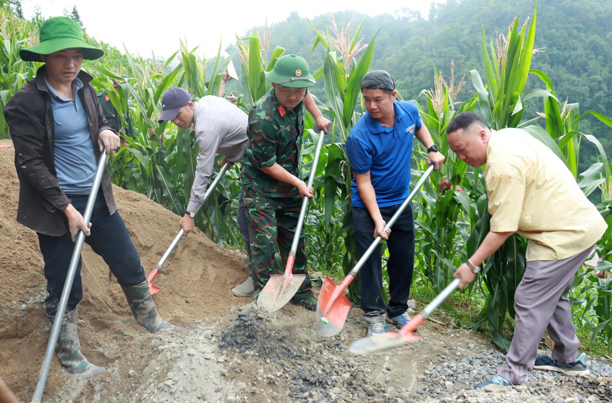 Cán bộ, chiến sỹ và Nhân dân xã Tùng Vài tham gia làm đường bê tông.