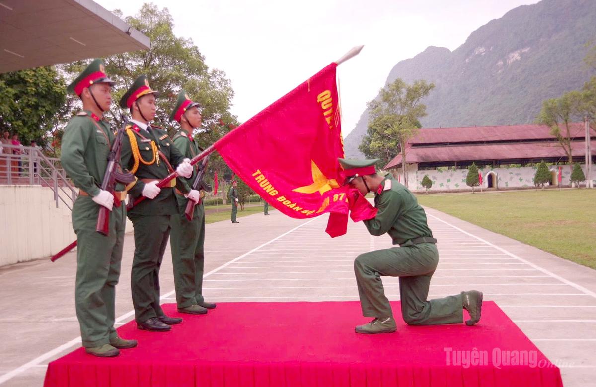 Chiến sĩ mới thực hiện nghi thức hôn Quân kỳ tại Lễ tuyên thệ chiến sĩ mới năm 2026.