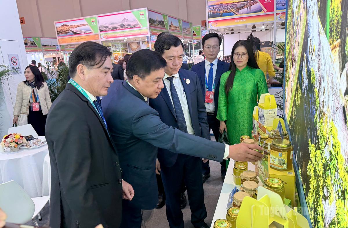 Thứ trưởng Bộ Công thương Nguyễn Sinh Nhật Tân và các đại biểu tham quan gian hàng của tỉnh Tuyên Quang tại Hội chợ.