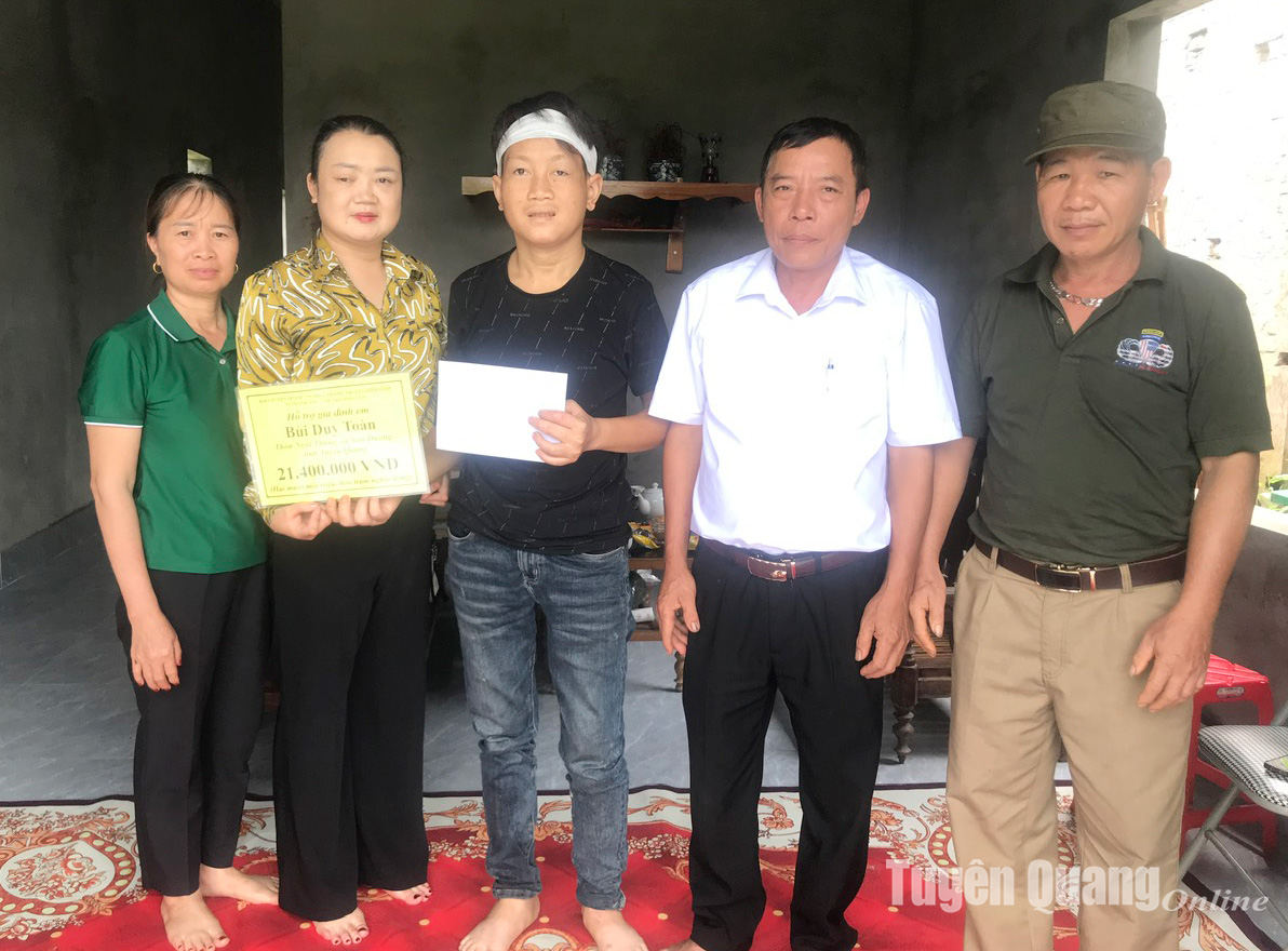 Đại diện Báo và Phát thanh, Truyền hình Tuyên Quang, Ban công tác Mặt trận thôn Ngãi Thắng, xã Sơn Dương trao tiền hỗ trợ cho em Bùi Duy Toàn.