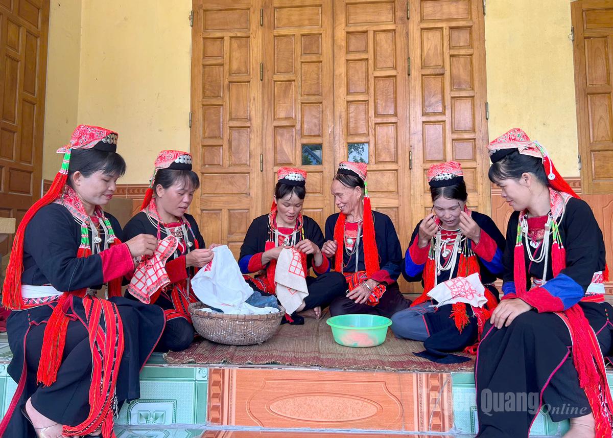 Members of the Eo Village Youth Club for Preserving Ethnic Cultural Identity embroider traditional costumes together.