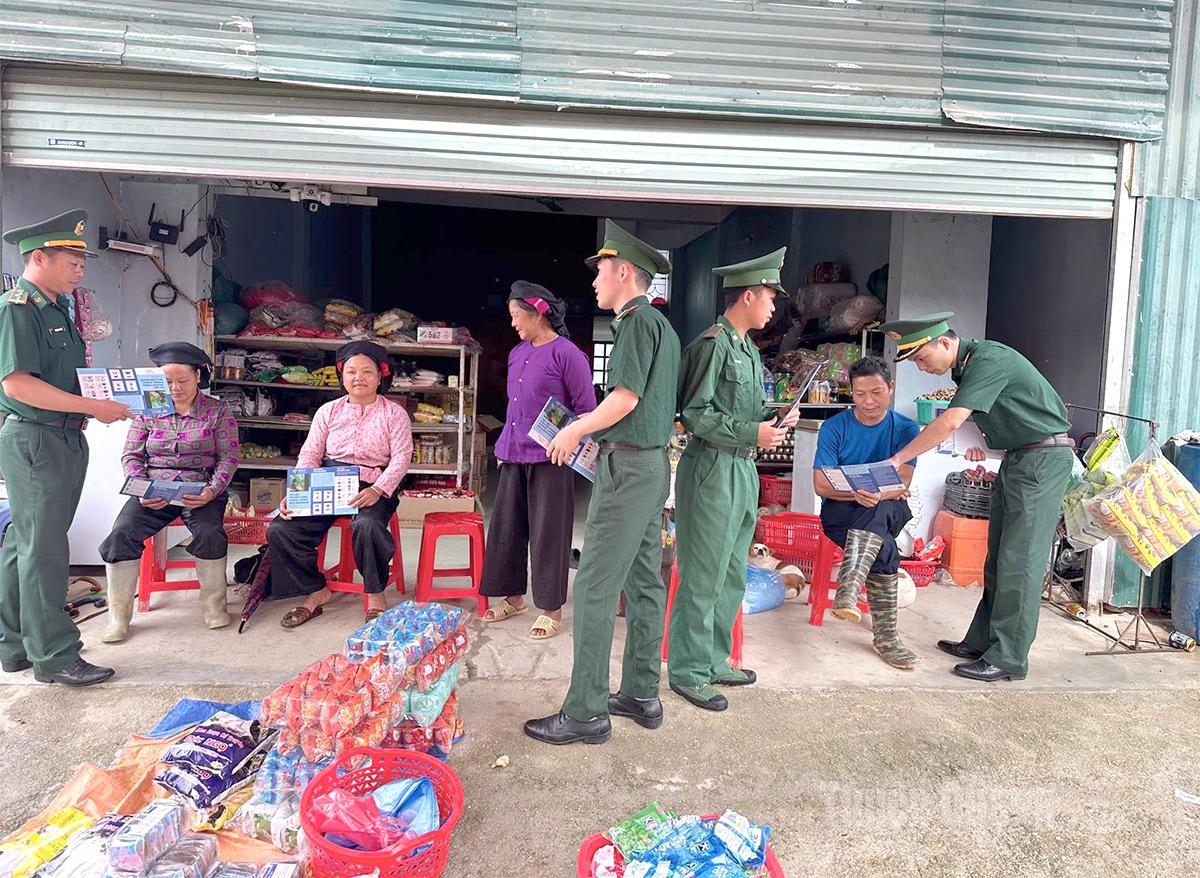 Cán bộ, chiến sĩ đồn Biên phòng Bản Máy tuyên truyền phòng chống tội phạm mua bán người tại chợ phiên.