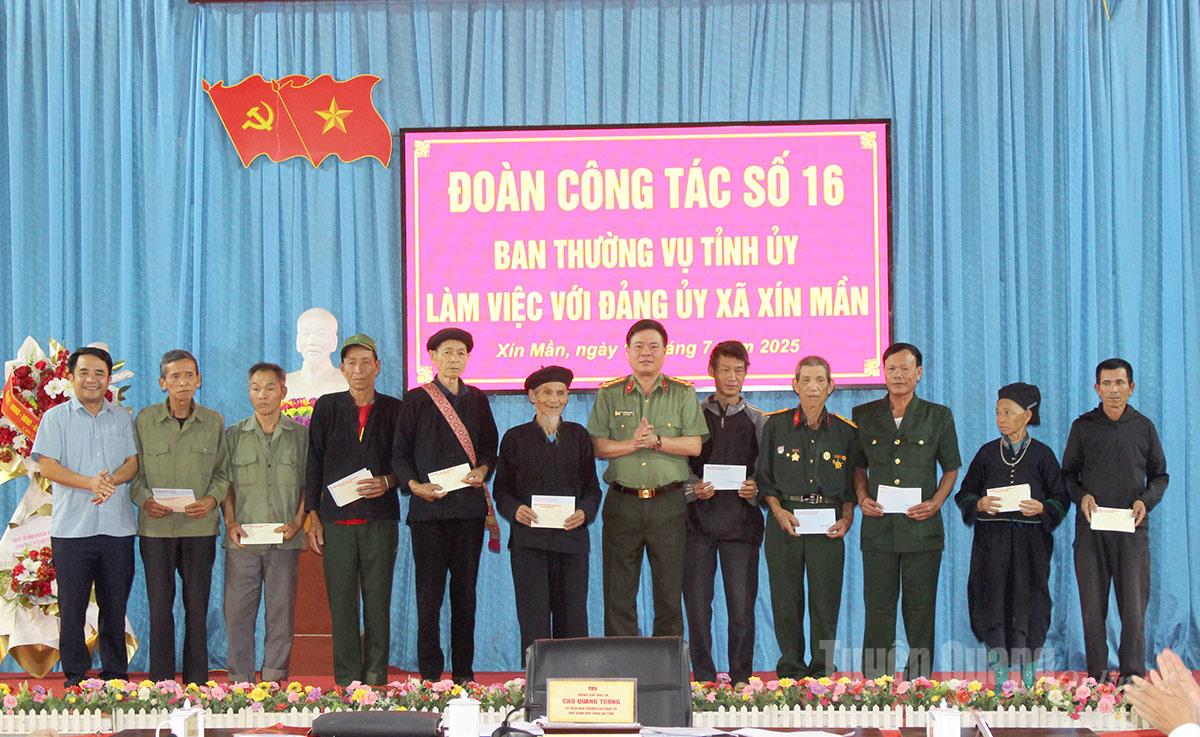 Đại tá Chu Quang Trung, Phó Giám đốc Công an tỉnh tặng quà cho các gia đình chính sách trên địa bàn xã Xín Mần. Ảnh: Nguyễn Yếm
