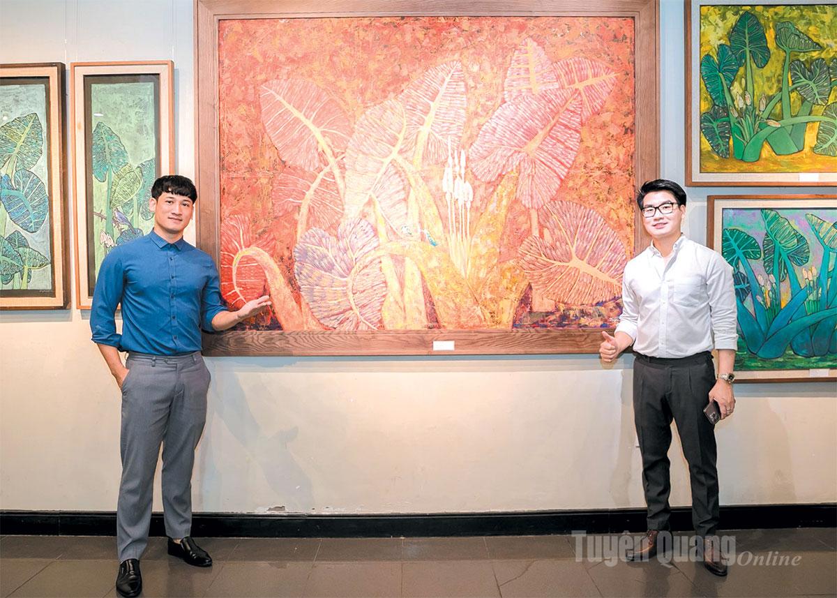 Họa sĩ Dương 
Xuân Quyền (trái) 
bên nhóm tác phẩm 
Hoa dọc mùng.