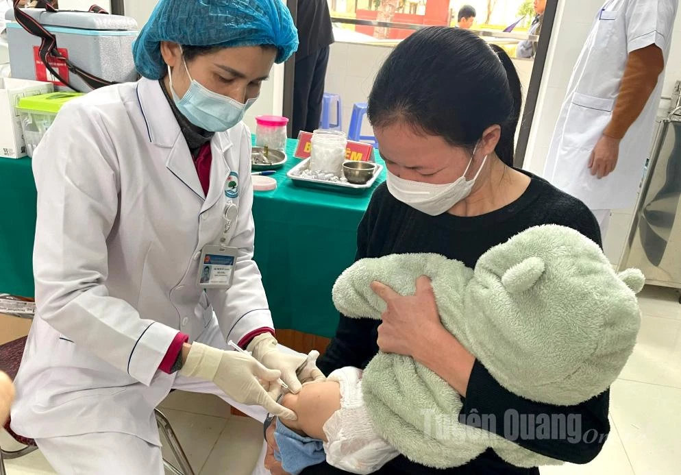 Cán bộ y tế tiêm phòng cho trẻ em tại xã Bình Yên.