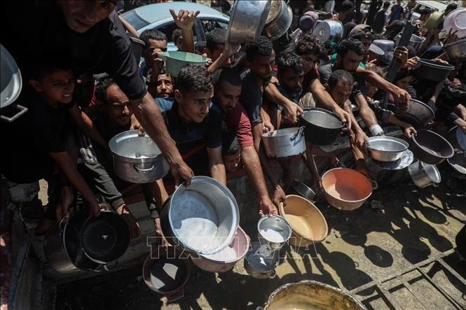 Người dân Palestine nhận thức ăn cứu trợ tại thành phố Gaza. Ảnh: THX/TTXVN