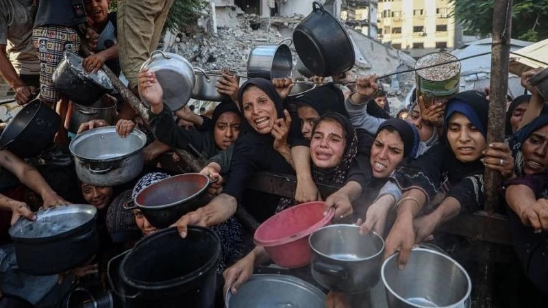 Người dân Palestine phải di dời chờ nhận thực phẩm miễn phí từ một trung tâm phân phối thực phẩm ở Thành phố Gaza, ngày 14/7/2025.(Ảnh: THX)
