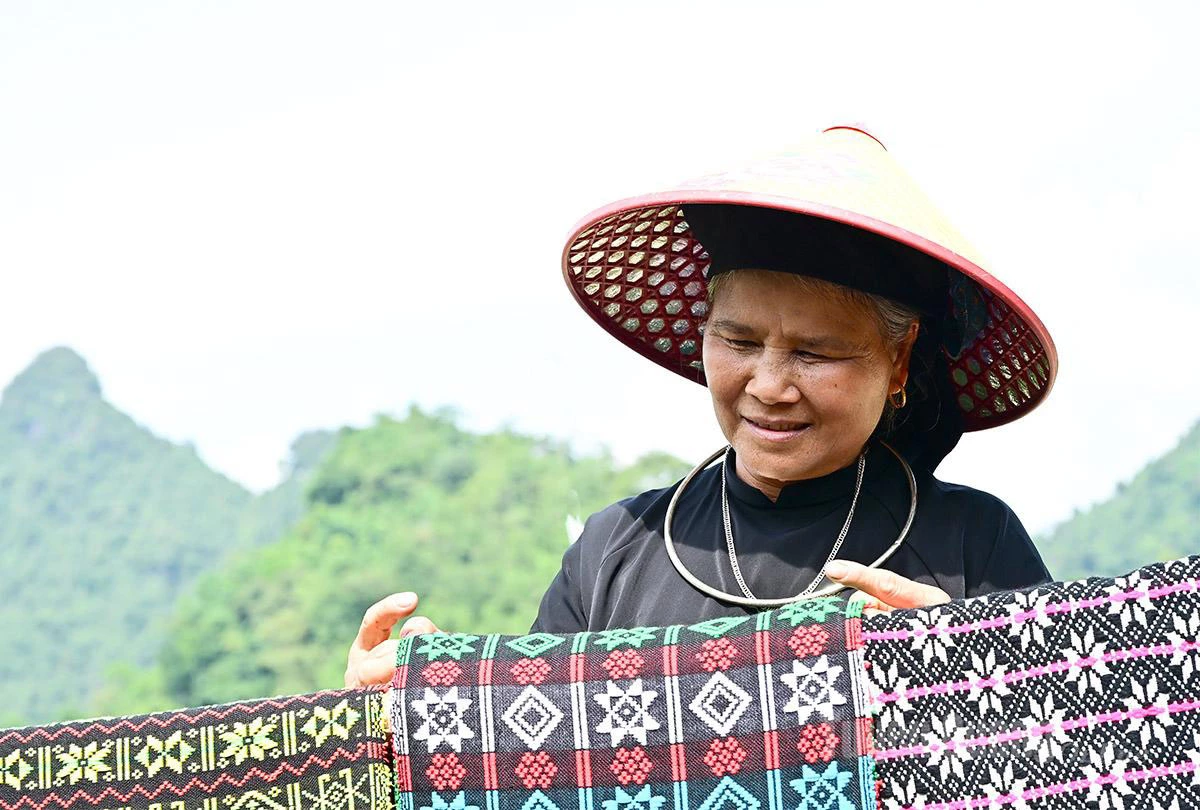 Mrs. Ma Thi Mau is very satisfied with the batch of products recently embroidered by the women.