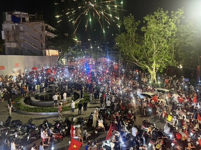 People gather at Dong Kinh Nghia Thuc Square, proudly carrying the national flag to celebrate the victory. 
