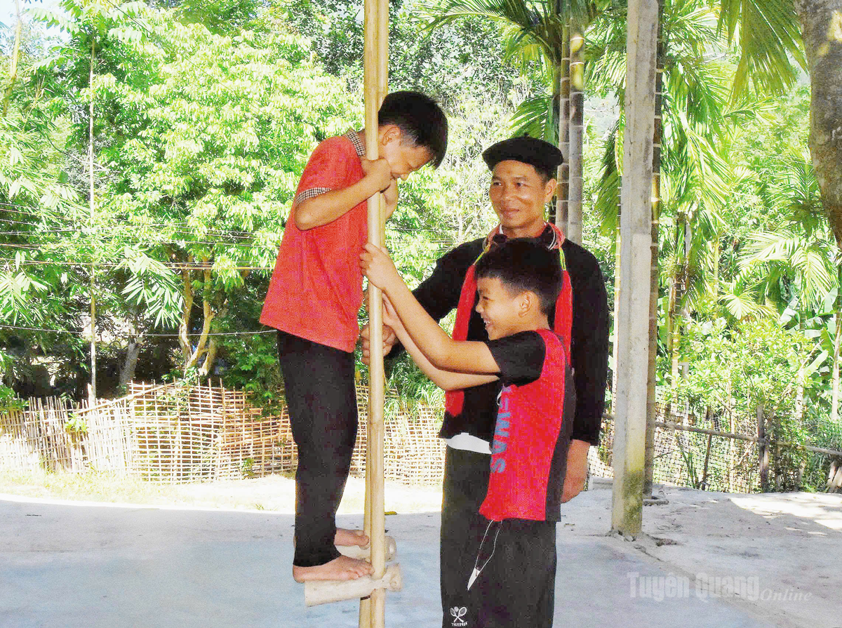 Anh Triệu Tống Giang hướng dẫn các em nhỏ trong thôn tập luyện trò chơi cà kheo truyền thống.