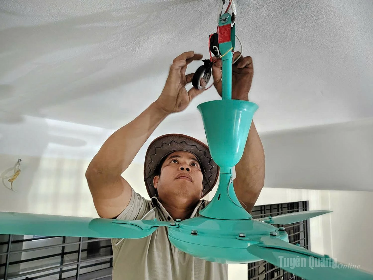 Inside the classrooms, most construction work has been completed. Ha Van Luong, a member of the electrical and plumbing team, is carefully installing ceiling fans.