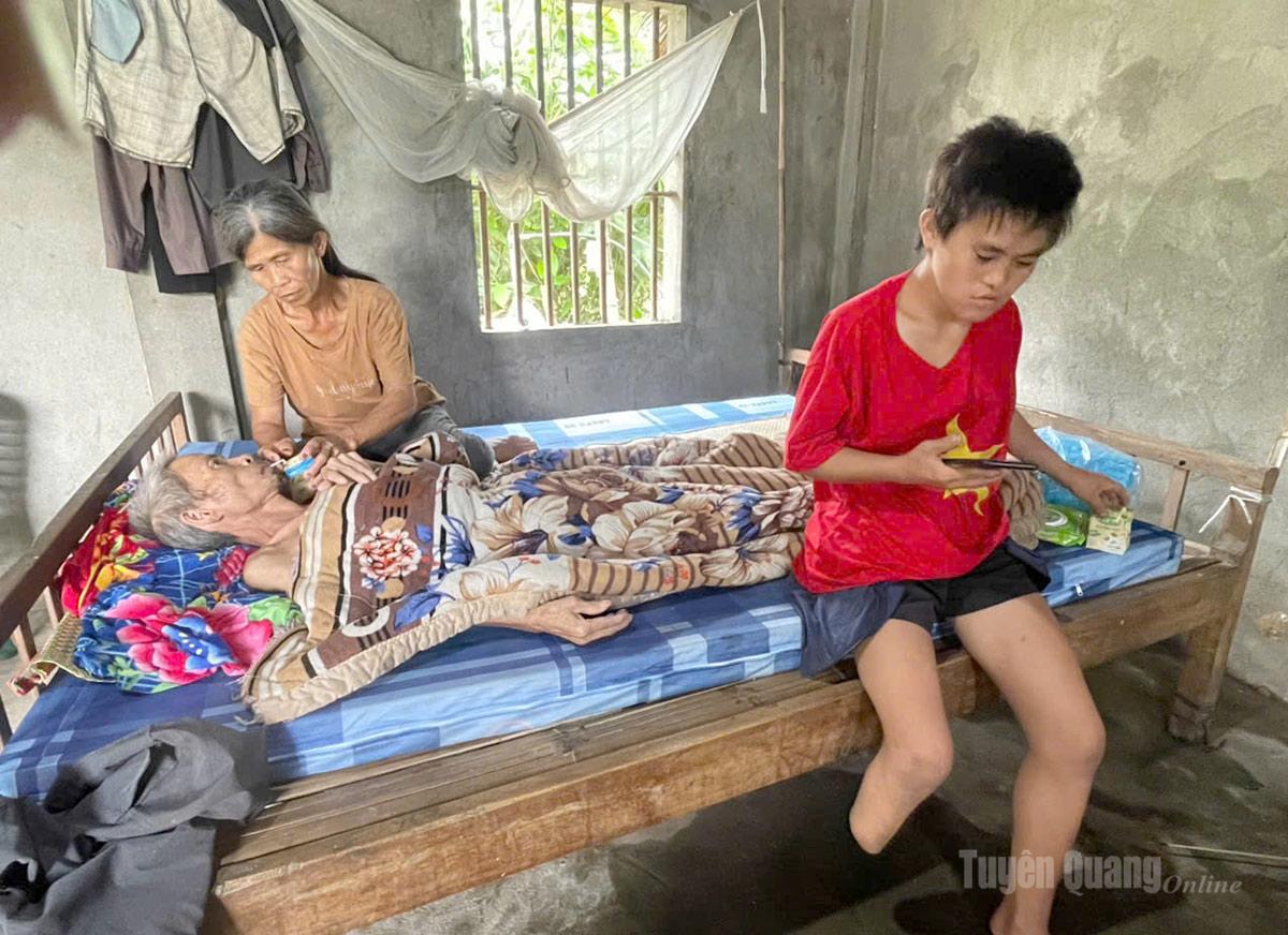 Chị Hoàng Thị Hó, thôn Thác Vệ, xã Bằng Hành, tỉnh Tuyên Quang đang chăm sóc chồng nằm liệt và con gái khuyết tật.