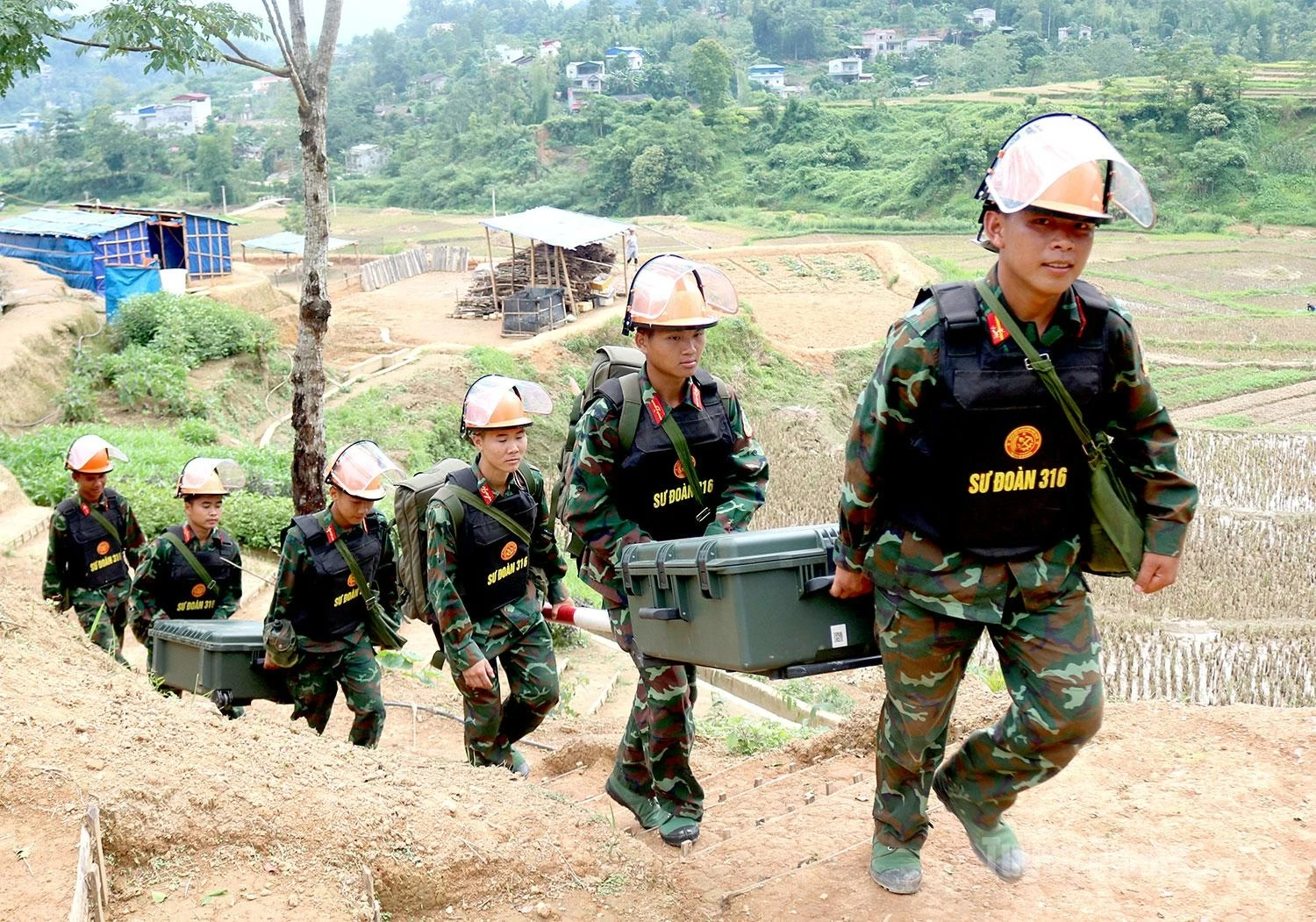 Combat engineers march into the clearance area carrying modern detection equipment, beginning another day of hazardous duty.