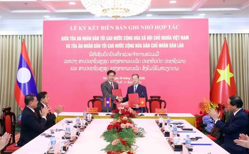 Chief Justice of the Supreme Peoples Court of Viet Nam Nguyen Van Quang and President of the Supreme Peoples Court of Laos Phayvy Syboualypha sign a new memorandum of understanding (MoU) on cooperation between the two courts. (Photo: VNA)