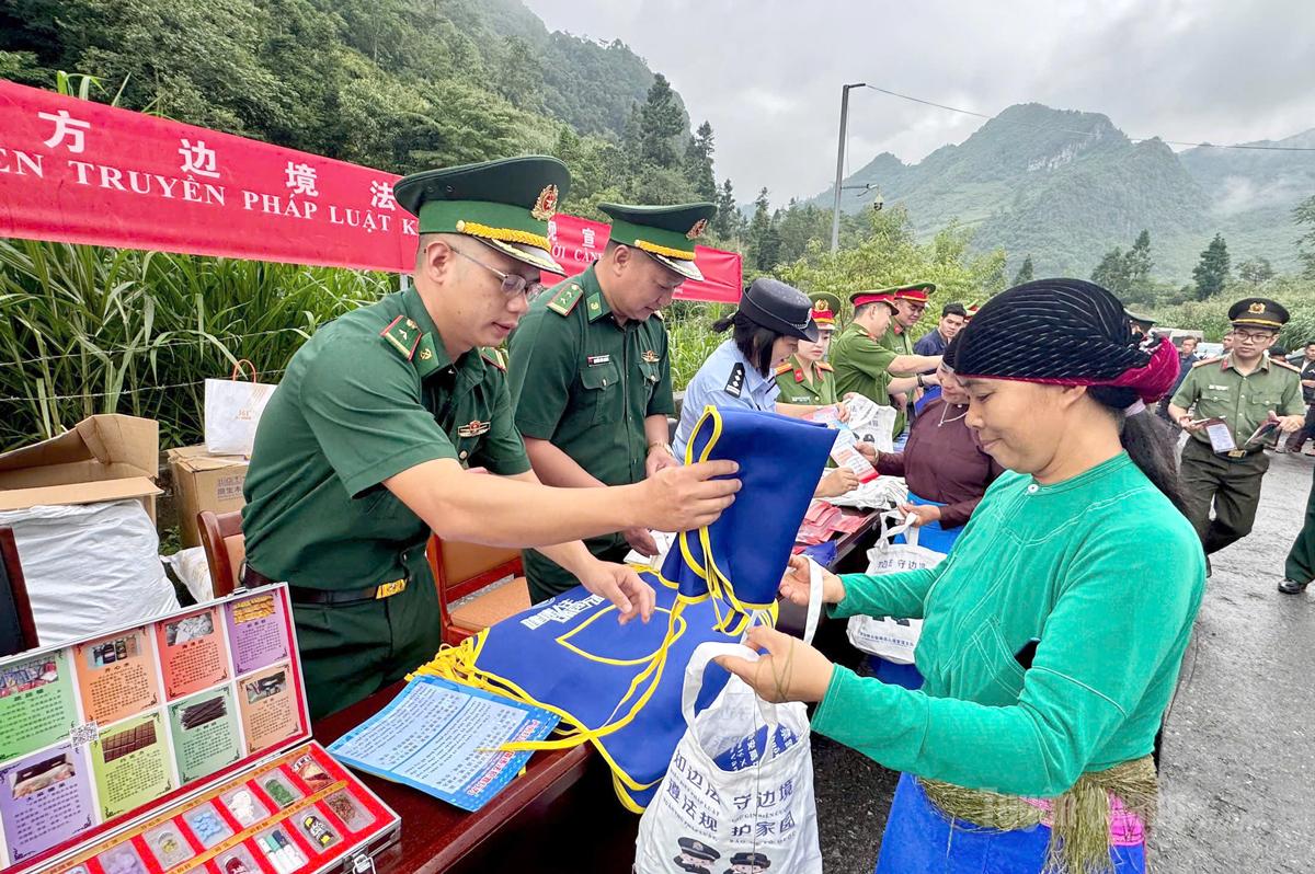 Cán bộ Đồn Biên phòng Phó Bảng phát tờ rơi và nhu yếu phẩm cho người dân khu vực biên giới.