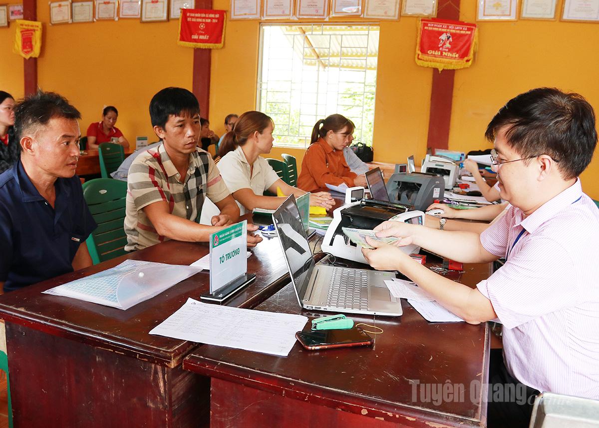 Cán bộ Phòng Giao dịch Ngân hàng 
chính sách xã hội Hàm Yên giải ngân vốn cho người dân xã Hùng Đức.
