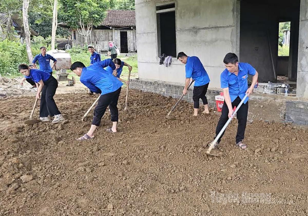 Đoàn viên thanh niên xã Linh Hồ hỗ trợ hộ nghèo san gạt mặt bằng sân.