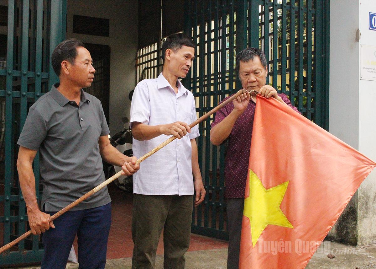 Tổ trưởng Tổ dân phố 8 Quang Trung, phường Hà Giang 2, Nguyễn Quang Nhiên (bên trái) triển khai việc treo cờ Tổ quốc mừng Quốc khánh 2/9.