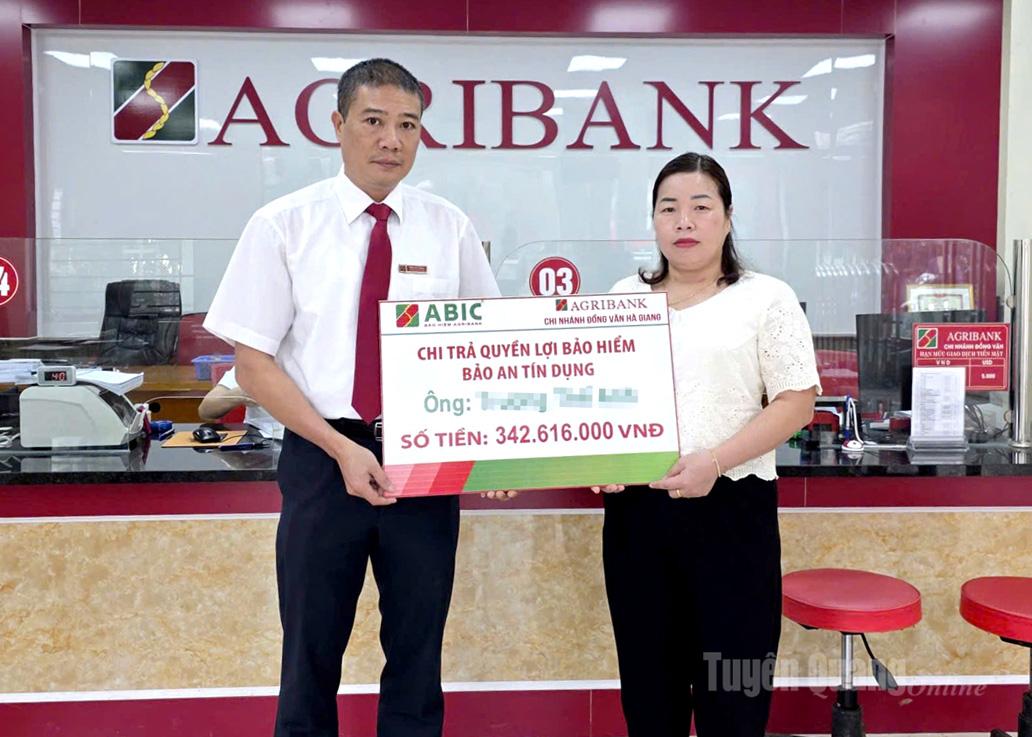 Đại diện lãnh đạo Agribank Chi nhánh Đồng Văn trao Quyền lợi bảo hiểm Bảo an tín dụng cho khách hàng.