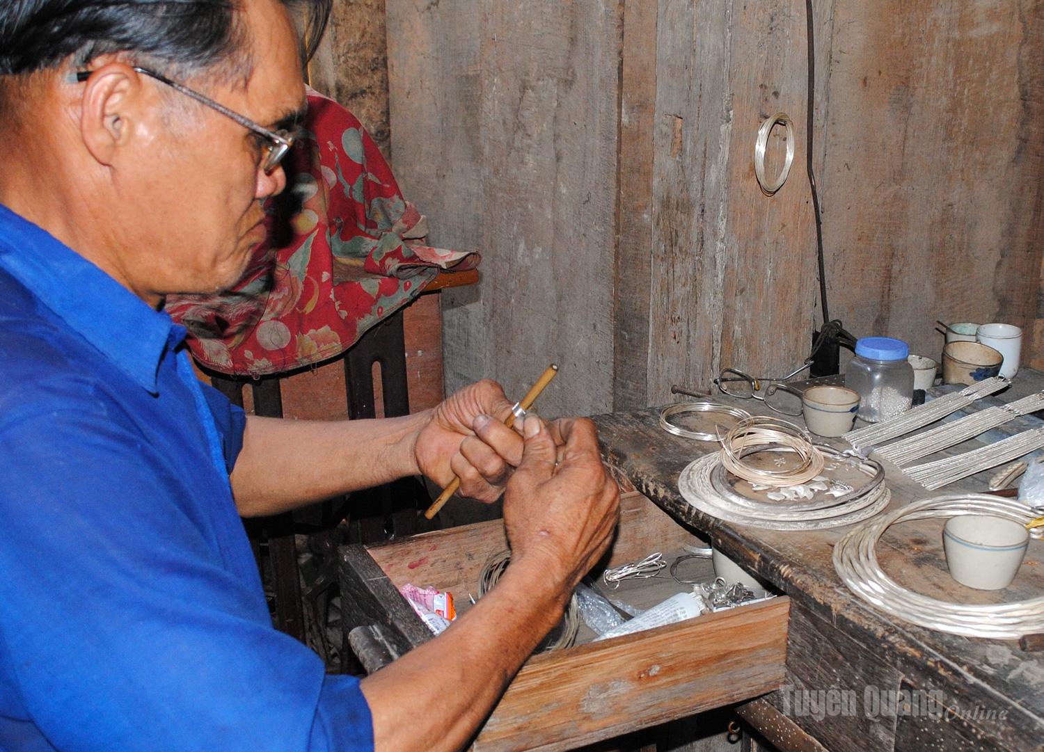 A Tay silversmith carefully engraves intricate patterns on silver jewelry. With skilled hands and an eye for detail, each piece of silver is transformed into a unique work of art.