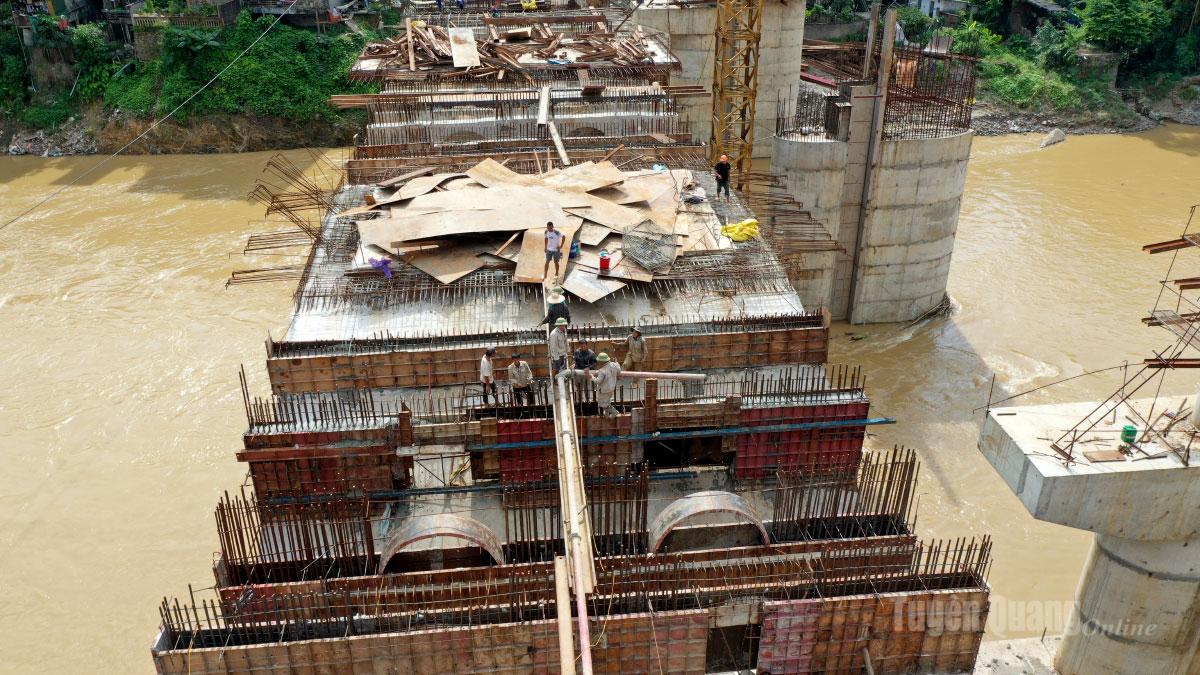 Machines work continuously, their roaring engines blending with the rushing river below