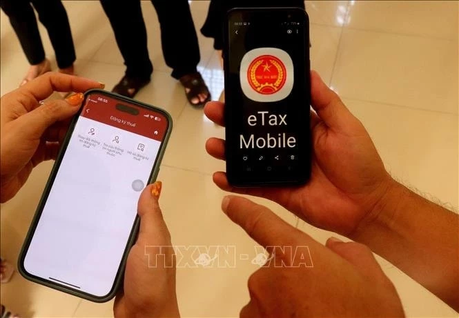 Người nộp thuế dùng ứng dụng eTax Mobile, ứng dụng Thuế điện tử dành cho cá nhân để kiểm tra thông tin trên Tờ khai quyết toán thuế thu nhập cá nhân gợi ý do hệ thống công nghệ thông tin của ngành Thuế tự động tạo lập. Ảnh: Thu Hiền/TTXVN