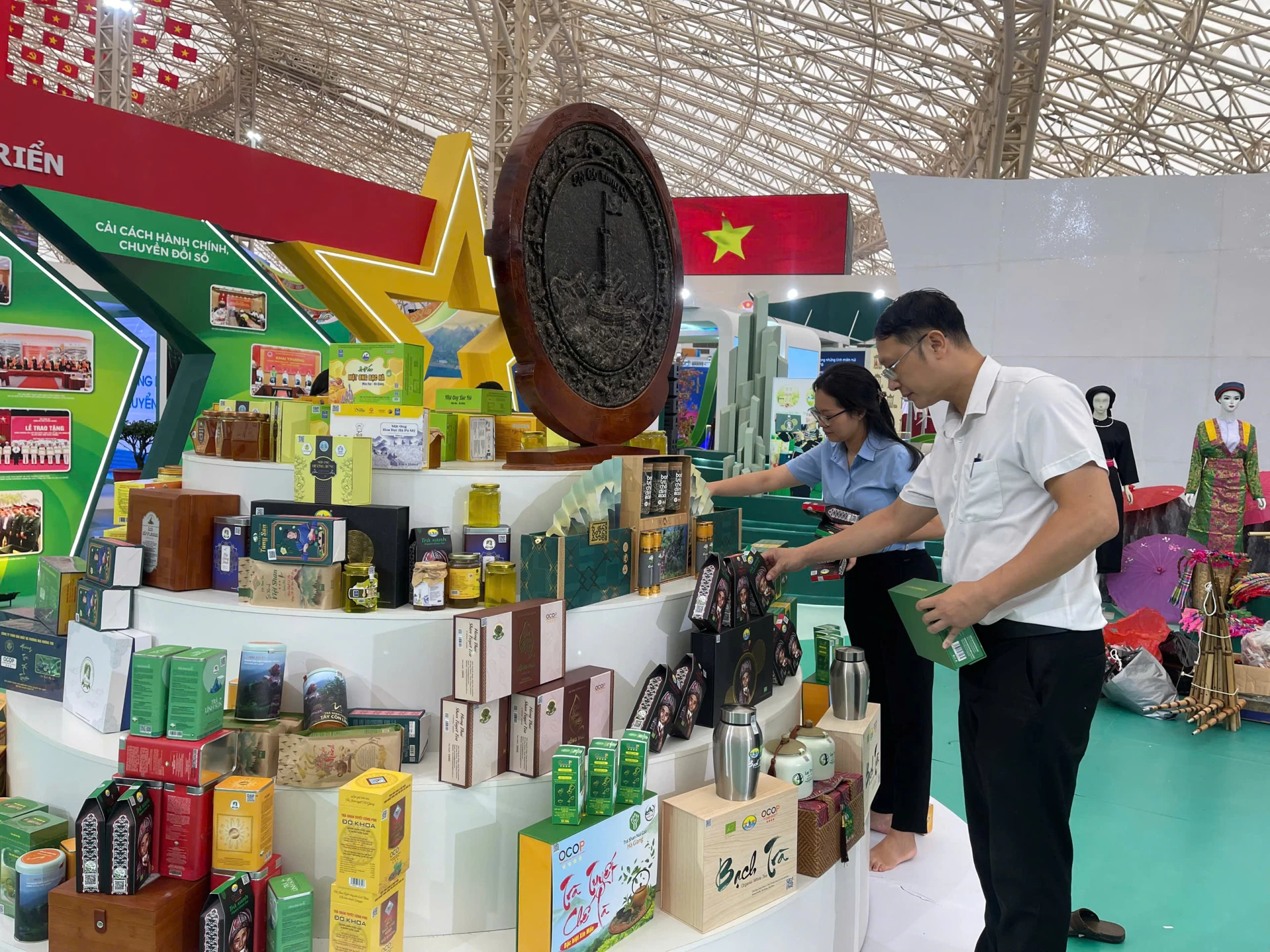 Cán bộ Trung tâm Khuyến công và Xúc tiến Công thương tỉnh sắp xếp gian hàng trưng bày tại triển lãm.
