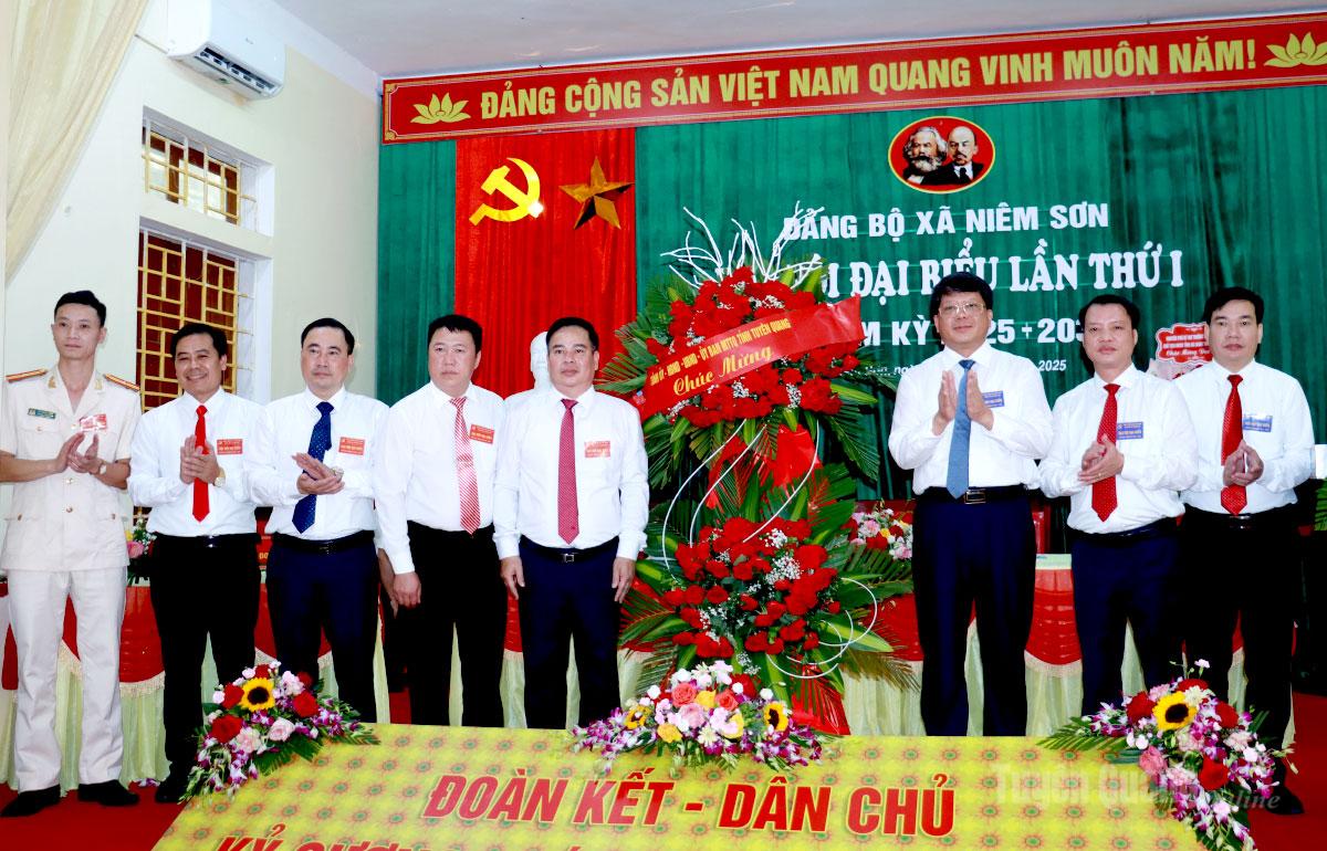 Phó Chủ tịch Thường trực Ủy ban MTTQ tỉnh Hà Trung Kiên tặng hoa chúc mừng Đại hội đại biểu Đảng bộ xã Niêm Sơn. Ảnh: Trần Kế