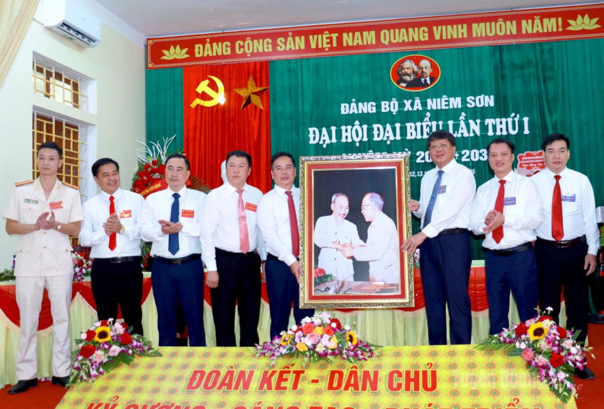 Phó Chủ tịch Thường trực Ủy ban MTTQ Việt Nam tỉnh Hà Trung Kiên tặng bức ảnh “Bác Hồ và Bác Tôn” cho xã Niêm Sơn. Ảnh: Trần Kế