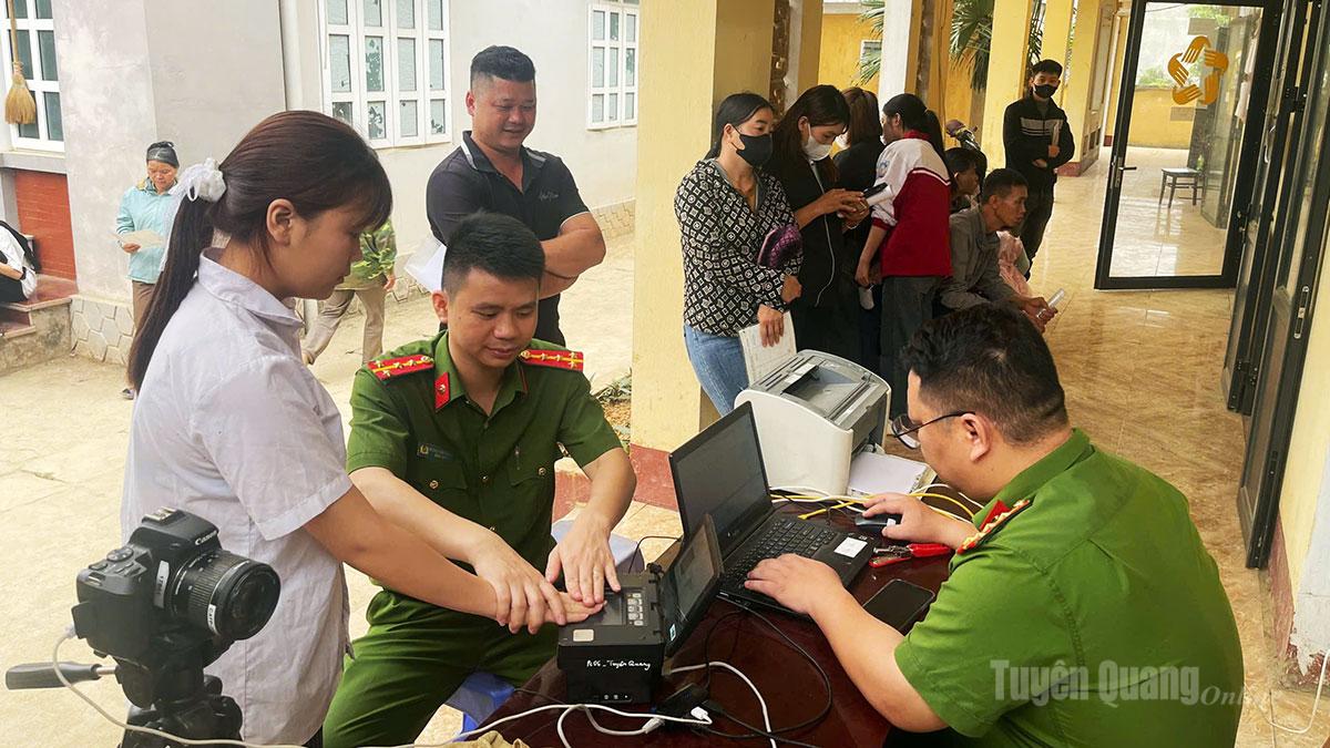 Cán bộ, chiến sỹ Công an xã Hùng Lợi hỗ trợ người dân và các em học sinh làm căn cước công dân.