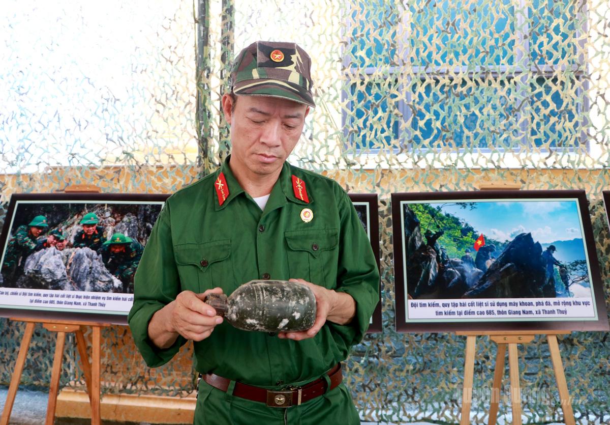 Cựu chiến binh 
Nguyễn Văn Kim bên những kỷ vật được tìm thấy 
trong quá trình tìm kiếm,  
quy tập hài cốt liệt sĩ.