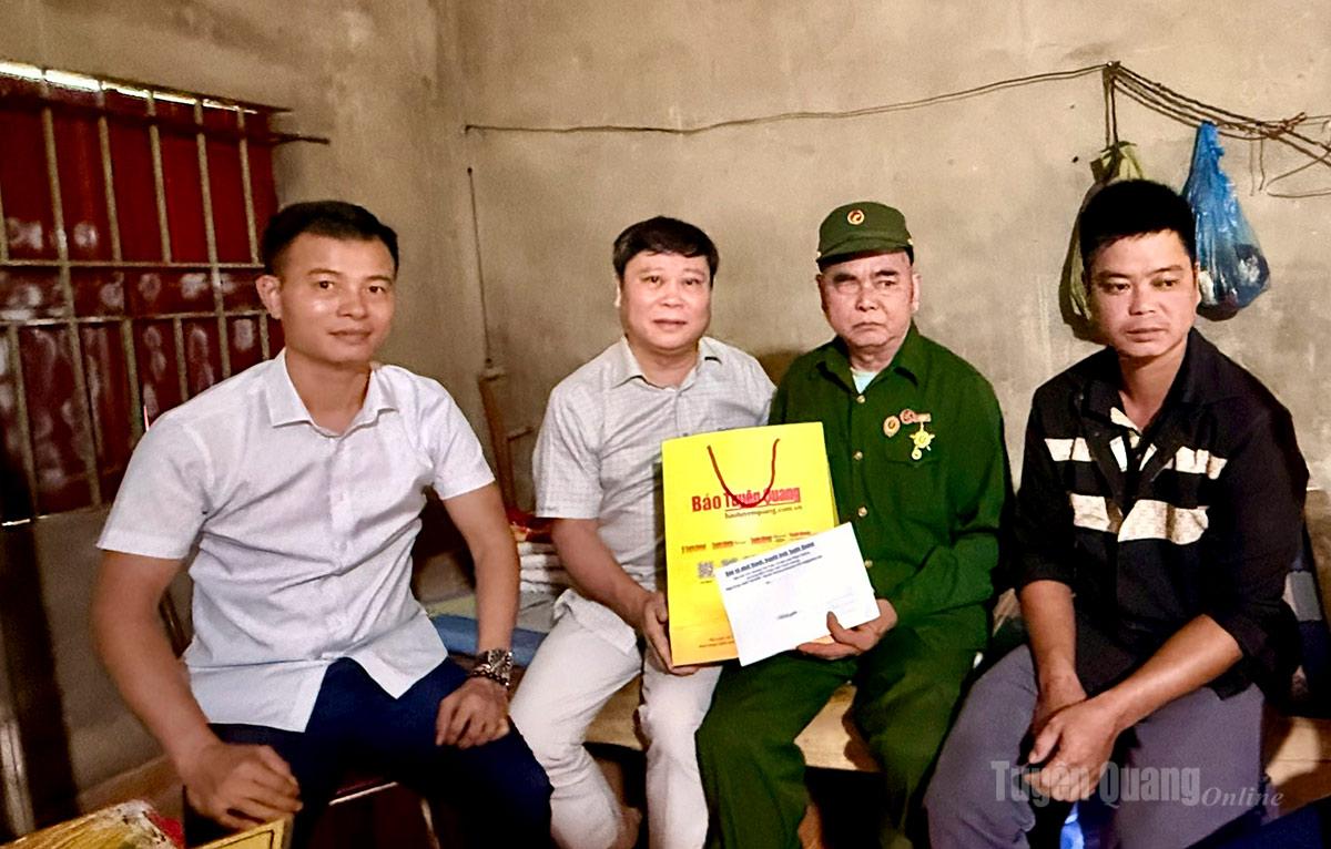 1. Đồng chí Mai Đức Thông, Ủy viên BCH Đảng bộ tỉnh, Giám đốc Báo và phát thanh, truyền hình Tuyên Quang, Chủ tịch Hội Nhà báo tỉnh tặng quà cho cựu chiến binh Sùng Sảo Minh, thôn Na Lan, xã Nấm Dẩn.