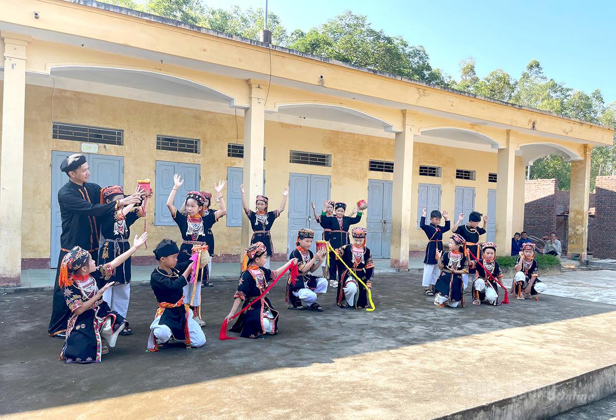 Thầy giáo Nguyễn Đình Kỷ hướng dẫn các em trong Câu lạc bộ giữ gìn văn hóa dân tộc Dao của trường tập múa.
