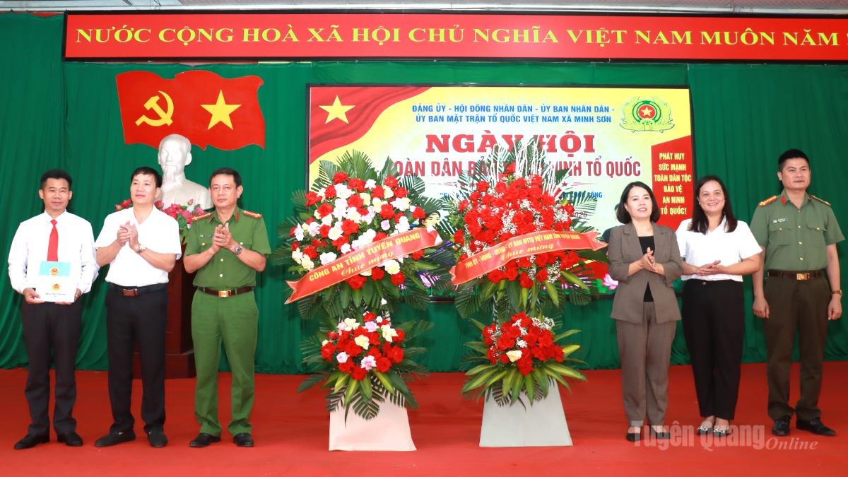 Đồng chí Lý Thị Lan, Phó Trưởng đoàn ĐBQH chuyên trách khóa XVI tỉnh và lãnh đạo Công an tỉnh tặng hoa chúc mừng Ngày hội Toàn dân bảo vệ an ninh Tổ quốc xã Minh Sơn.
