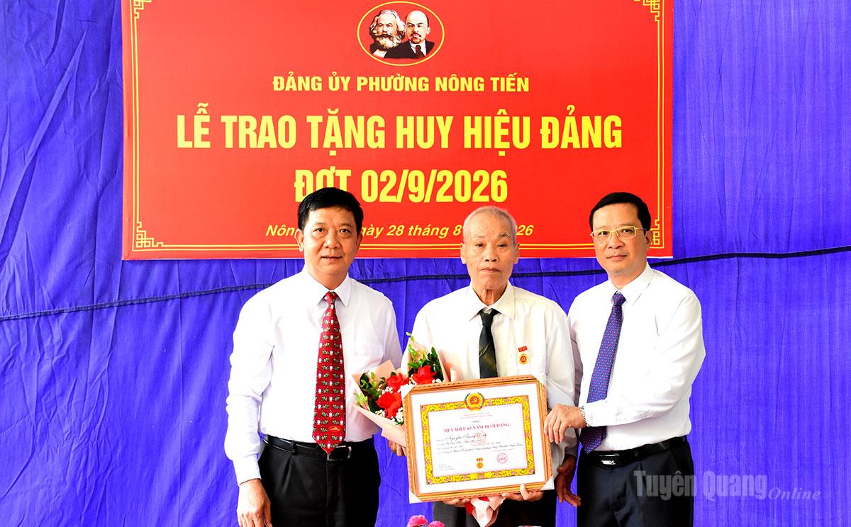 Đồng chí Nguyễn Khánh Lâm, Uỷ viên BCH Đảng bộ tỉnh, Giám đốc Sở Tư pháp trao Huy hiệu 65 năm tuổi Đảng cho đảng viên Nguyễn Trung Kính, tổ dân phố 4, Đảng bộ phường Nông Tiến,.