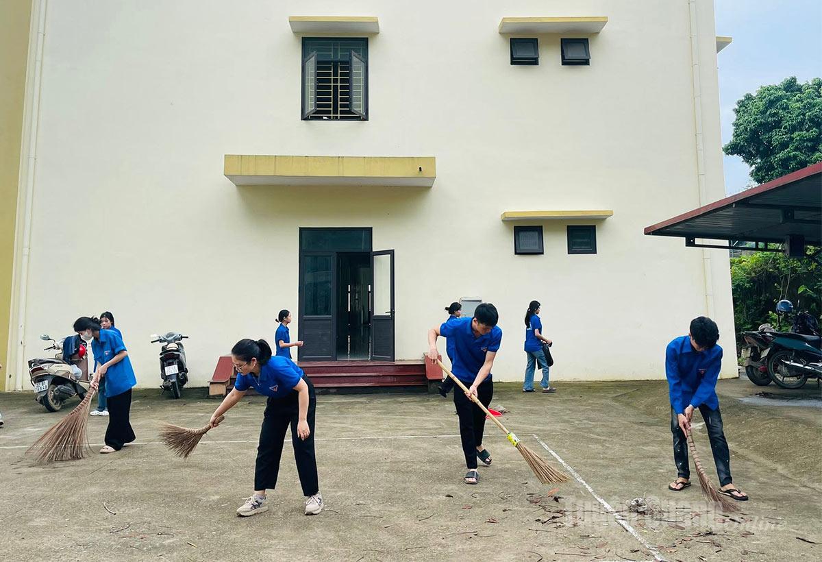Đoàn viên, thanh niên xã Minh Quang dọn dẹp vệ sinh khuôn viên trụ sở xã.