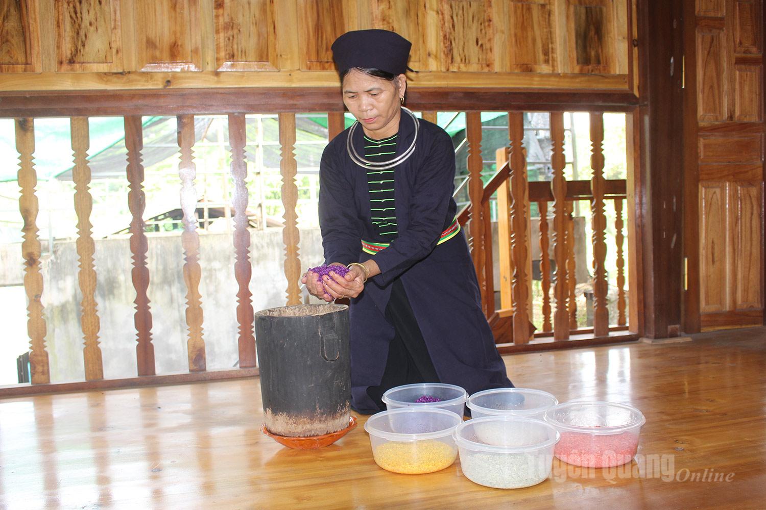 The Tay woman carefully places the rice into the steamer, preparing to cook the sticky rice.
