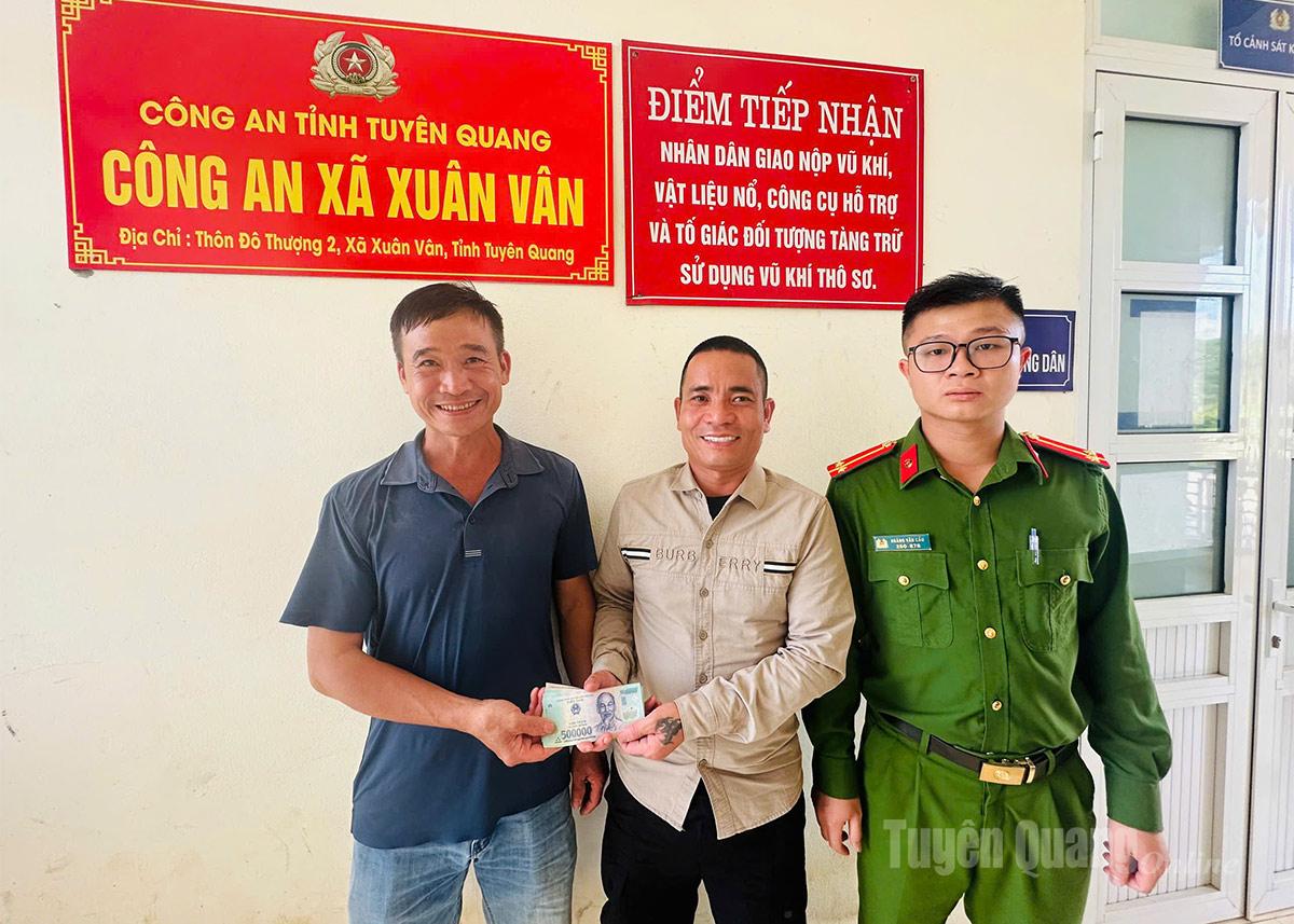 Ông Hoàng Văn Thoả (ngoài cùng bên trái) trả lại số tiền cho ông Nguyễn Văn Quang tại Công an xã.