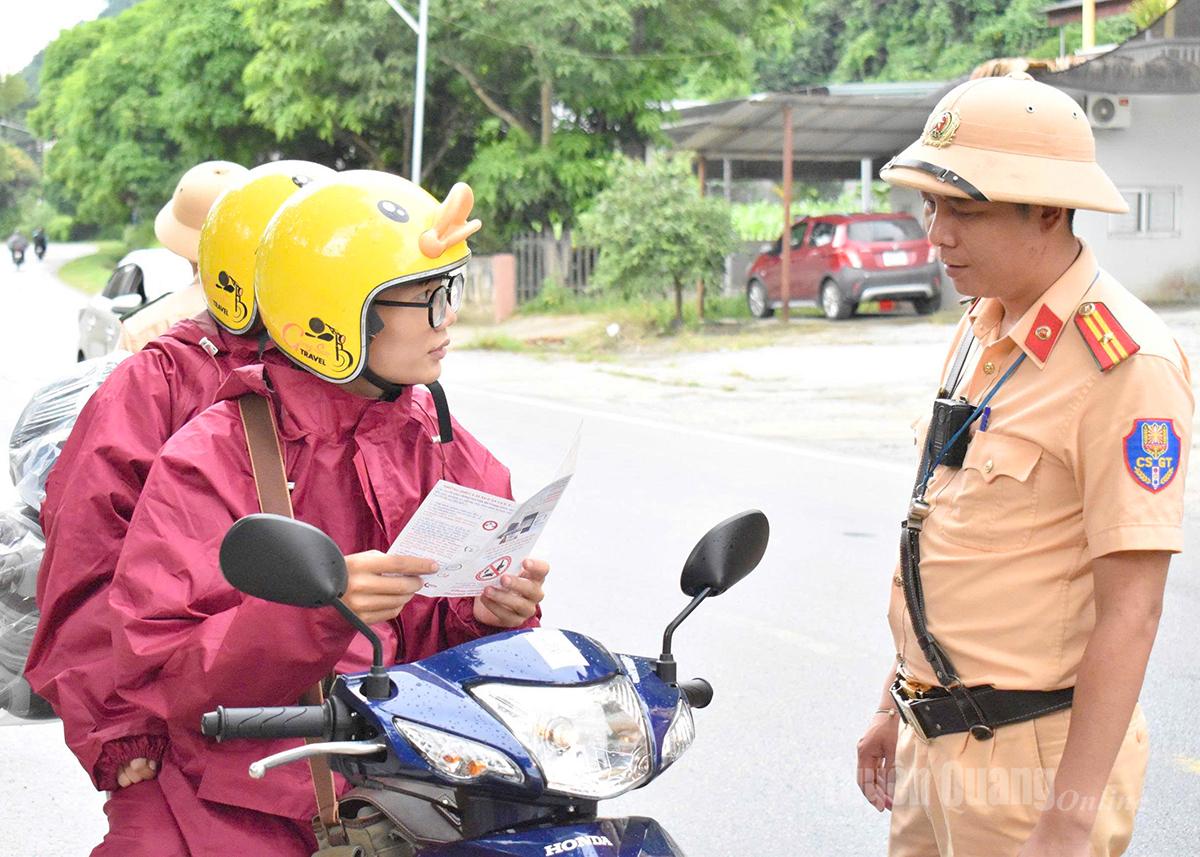 Cảnh sát giao thông phát tờ rơi cho du khách về kỹ năng lái xe ở khu vực đèo dốc.