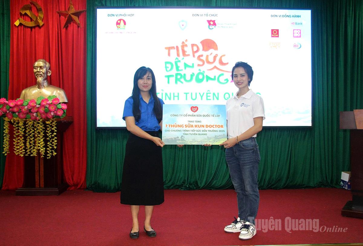 Đại diện nhà tài trợ trao tặng sữa cho các em học sinh.