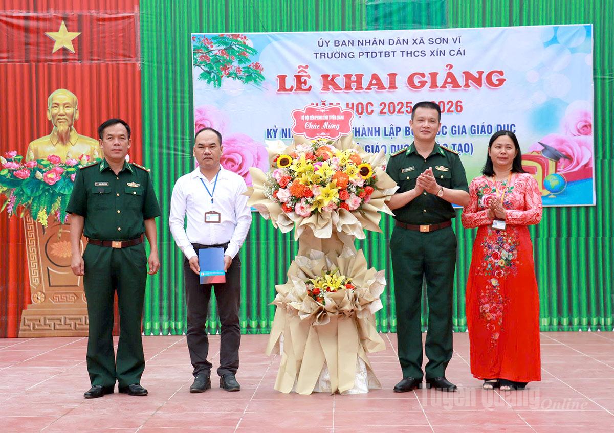 Đại tá Hoàng Ngọc Định, Phó Chỉ huy trưởng Bộ Chỉ huy Quân sự tỉnh tặng hoa chúc mừng trường Phổ thông Dân tộc bán trú THCS Xín Cái tại Lễ khai giảng năm học mới. Ảnh: Trần Kế