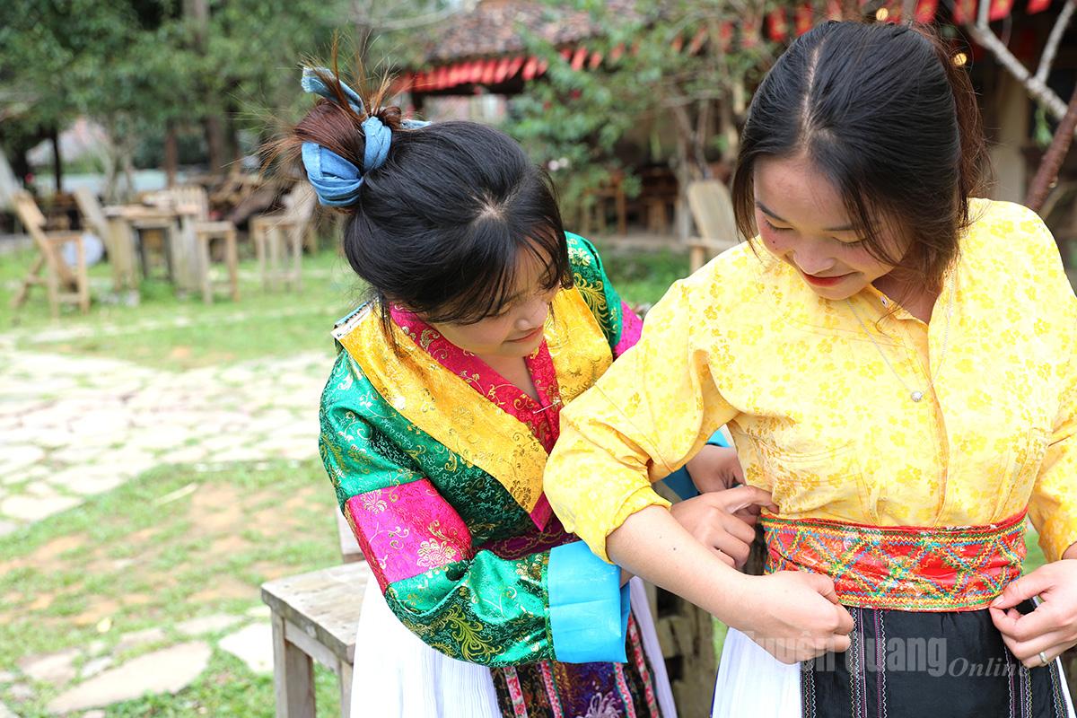 Local people help tourists wear the traditional costumes of the H’mong people.