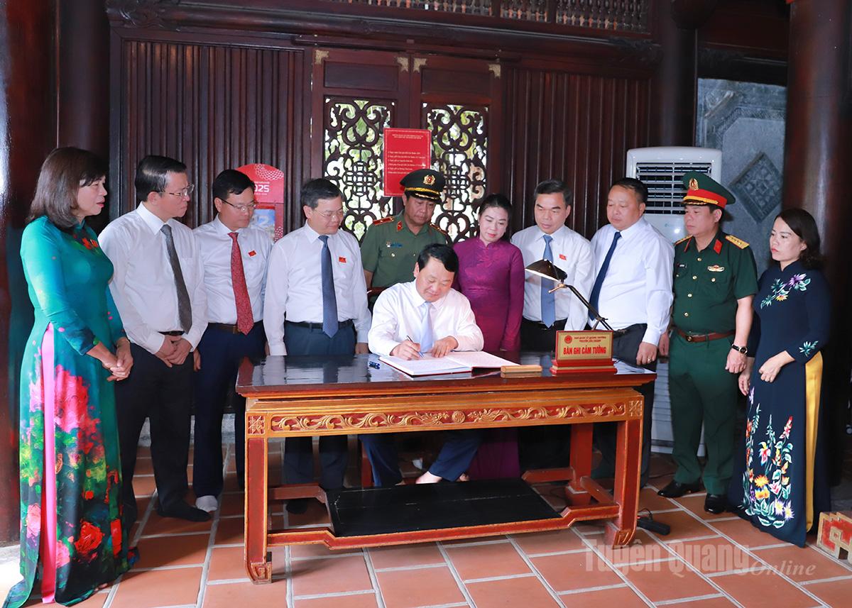 Bí thư Tỉnh uỷ Hầu A Lềnh ghi lưu bút vào Sổ truyền thống tại Đền thờ Chủ tịch Hồ Chí Minh. Ảnh: Huy Tuấn