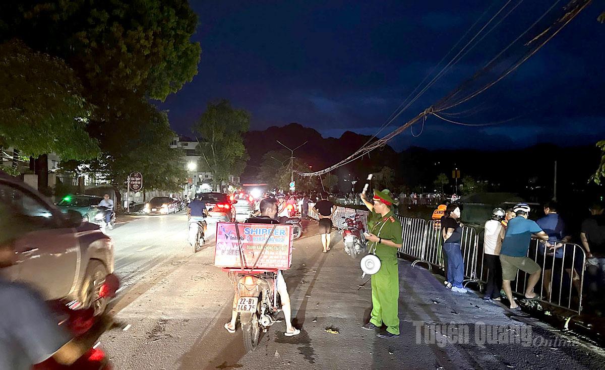 18h10 phút vẫn rất đông người dân theo dõi mực nước sông Lô đoạn qua địa bàn phường Minh Xuân. Lực lượng Công an phải túc trực phân luồng điều tiết giao thông, bảo đảm an ninh trật tự, nhắc nhở người dân không ra khu vực nguy hiểm. Ảnh Lý Thịnh